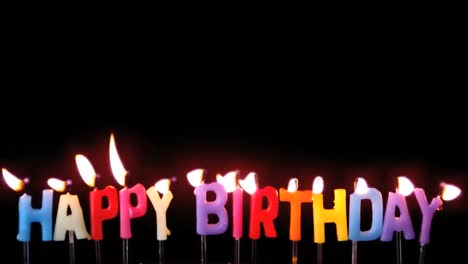 animation of red kaleidoscopic shapes over lit candles spelling happy birthday, blown out, on black