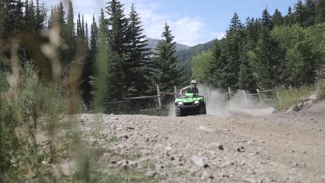 Shot-of-an-ATV-Rider-driving-his-quad-really-fast-around-a-corner,-leaving-a-large-dirt-cloud-behind-him