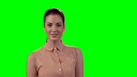 Smiling-beautiful-woman-standing-against-green-screen