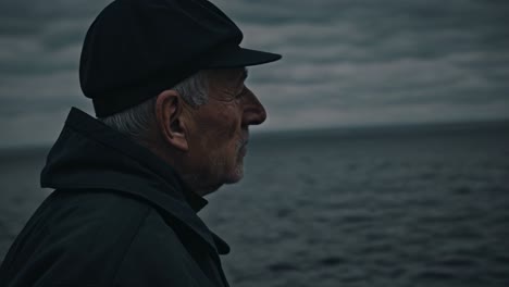 elderly man contemplating by the ocean