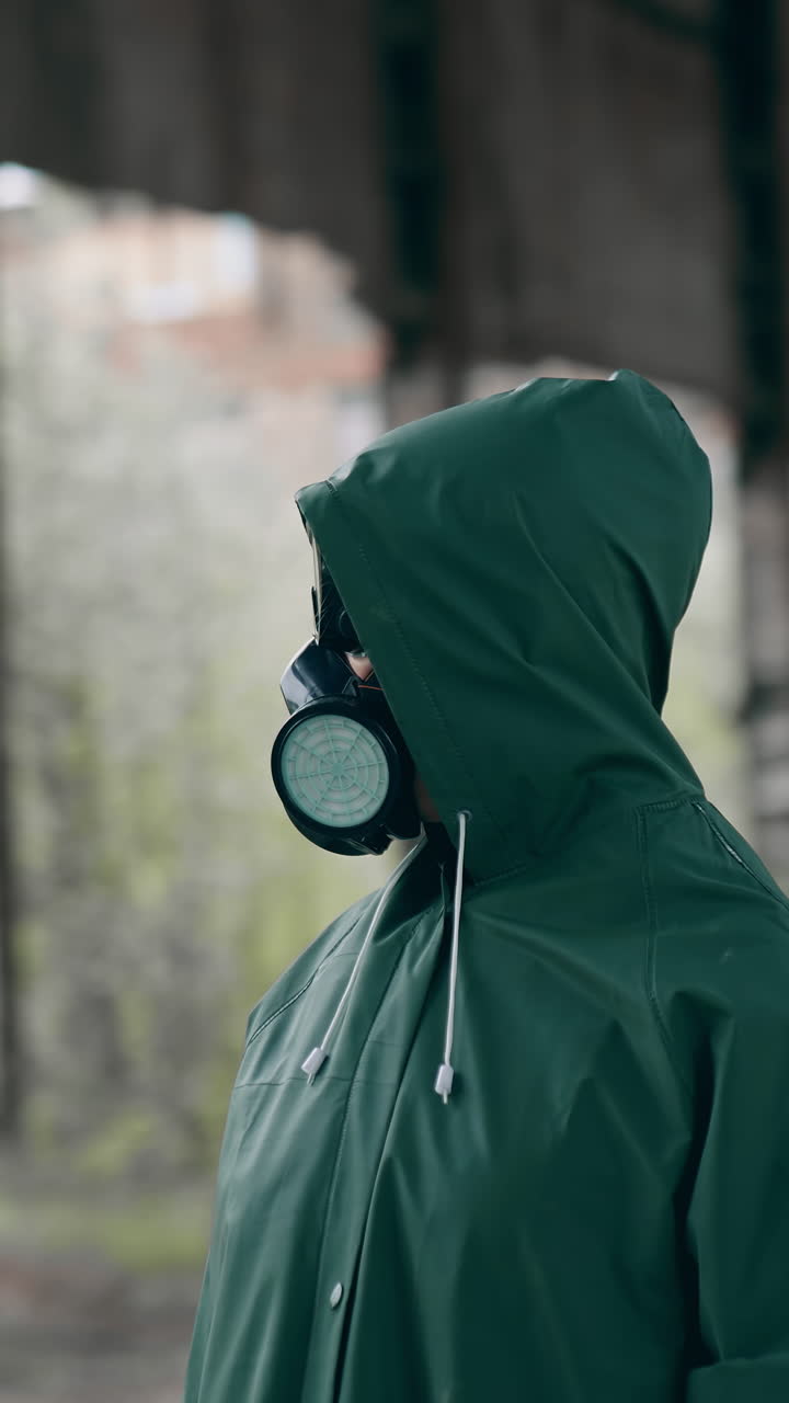 Man in gas mask and protective clothing. Man in gas mask and cloak for chemical protection on abandoned factory