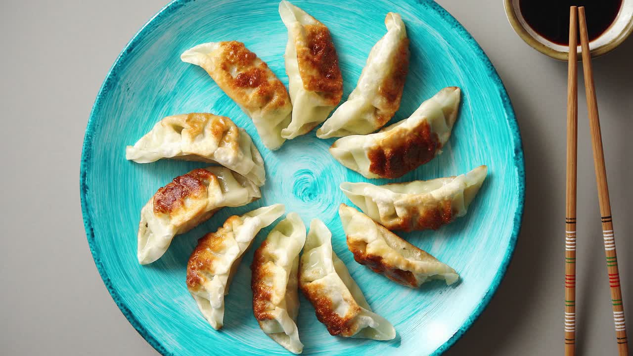 albóndigas asiáticas tradicionales gyozas en plato de cerámica turquesa