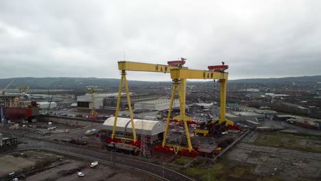 aerial shot of harland and wolff cranes in belfast shipyard on a cloudy day