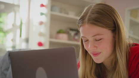 adolescente con aparatos ortopédicos acostada en la cama en casa transmitiendo una película en una tableta digital y riendo - filmada en cámara lenta