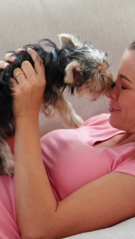 laughing woman playing with yorkshire terrier puppy