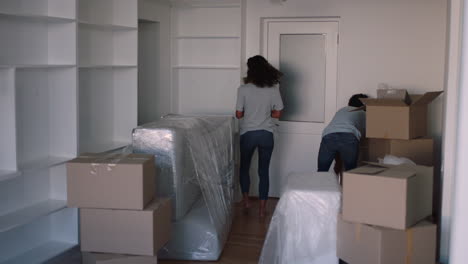 young couple moving house new home owners smiling enjoying successful move embracing in apartment