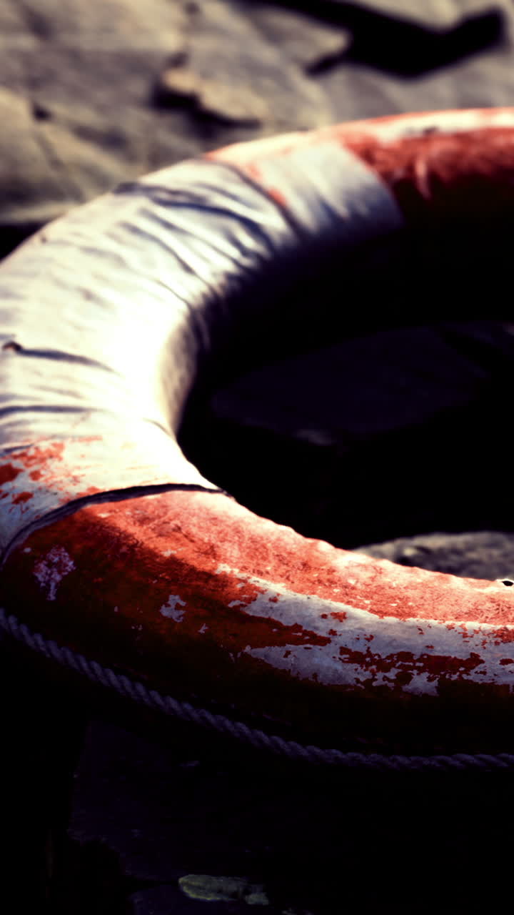 Lifebuoy resting on a rocky surface at an outdoor location near water