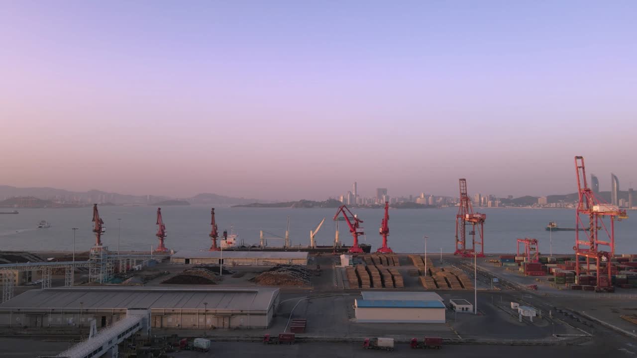video aéreo de grúas y contenedores en el muelle al anochecer
