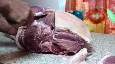 butchering bone in pork shoulder at home, separating meat with deboning knife