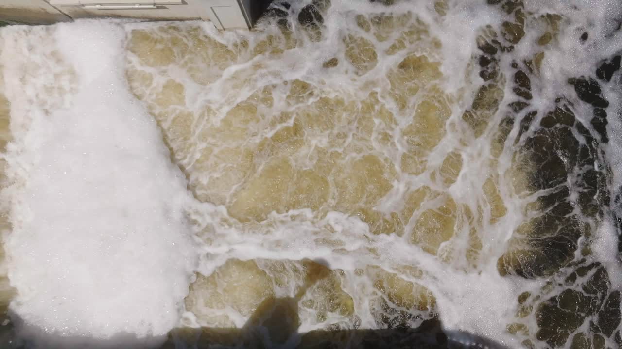 Drone view of water flowing into Mississippi river forming ripples.