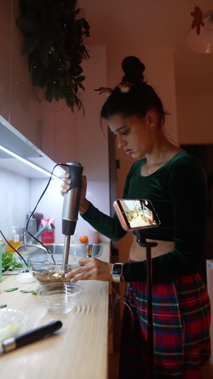 Woman cooking with an immersion blender in her kitchen