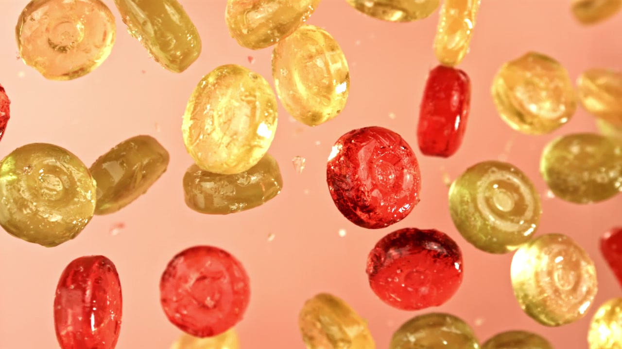 Caramelle rosse e gialle che cadono al rallentatore