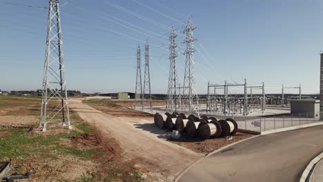 torres de acero con líneas de transmisión de energía de la granja de producción de paneles solares, ascenso aéreo