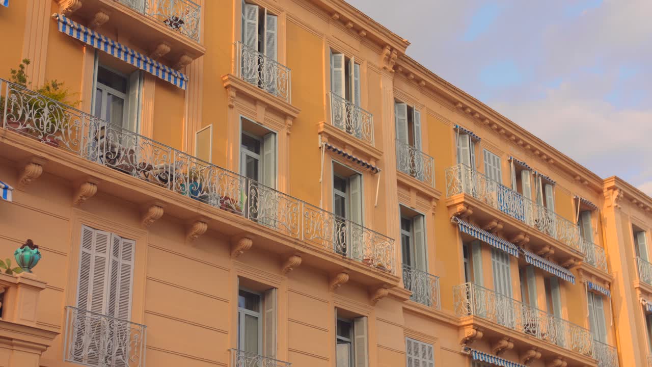 Explore os intrincados detalhes arquitetônicos do Riviera Palace em Menton, França. Este close-up captura o design e o charme únicos do edifício sob a luz do fim da tarde.