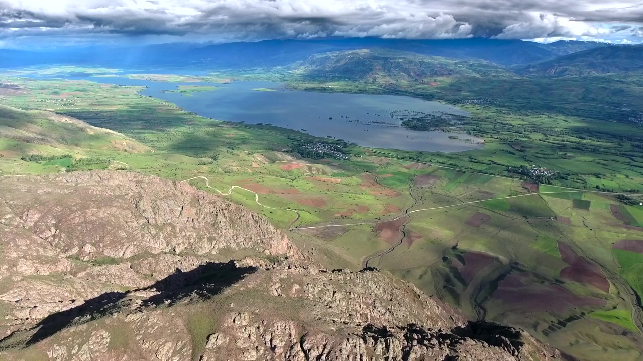 Vista aerea di paesaggio montuoso con lago e campi coltivati