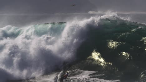 surfer on a surfboard in the middle of big wild foamy waves