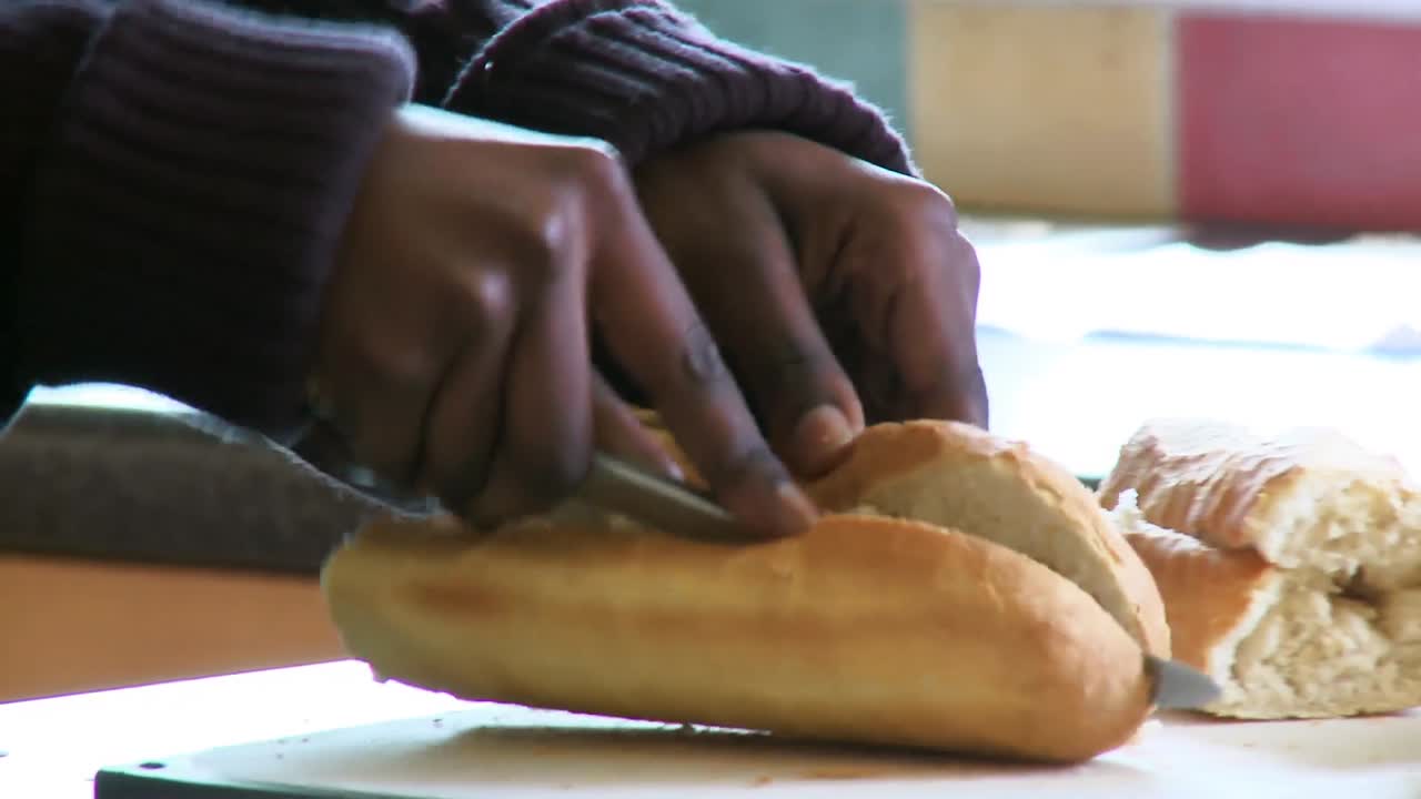 Close up of ethnic woman cutting bread