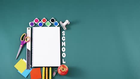 spiral book surrounded by school supplies