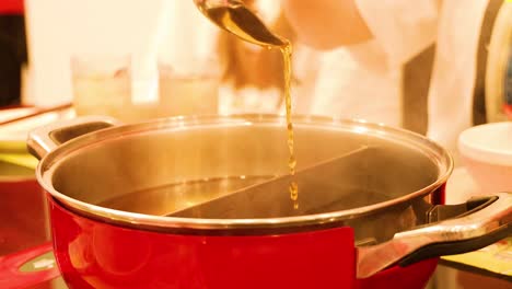 ladle pouring broth into a hot pot