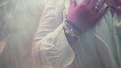 toma cinematográfica de un hombre lgbt con alas de ángel tocándose el cuello