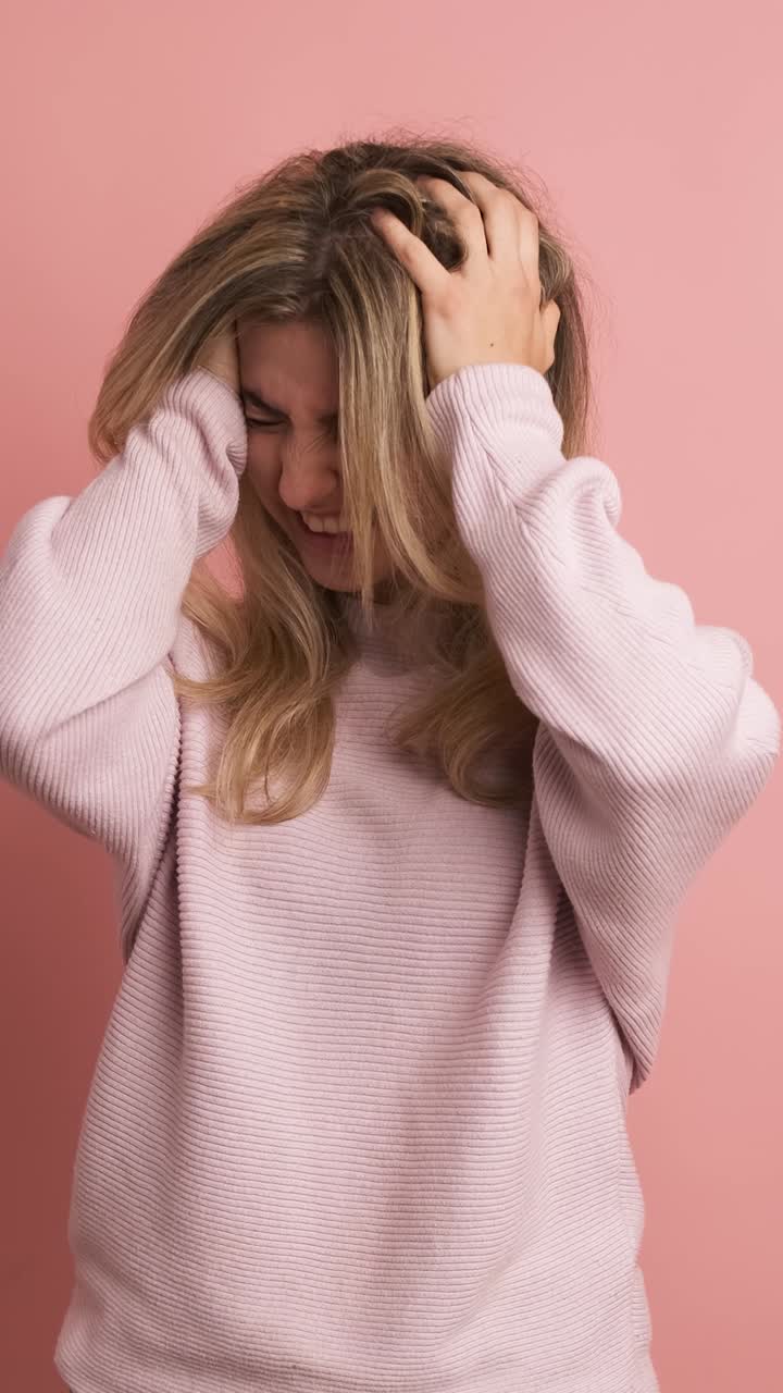 Woman gesturing headache hands on head