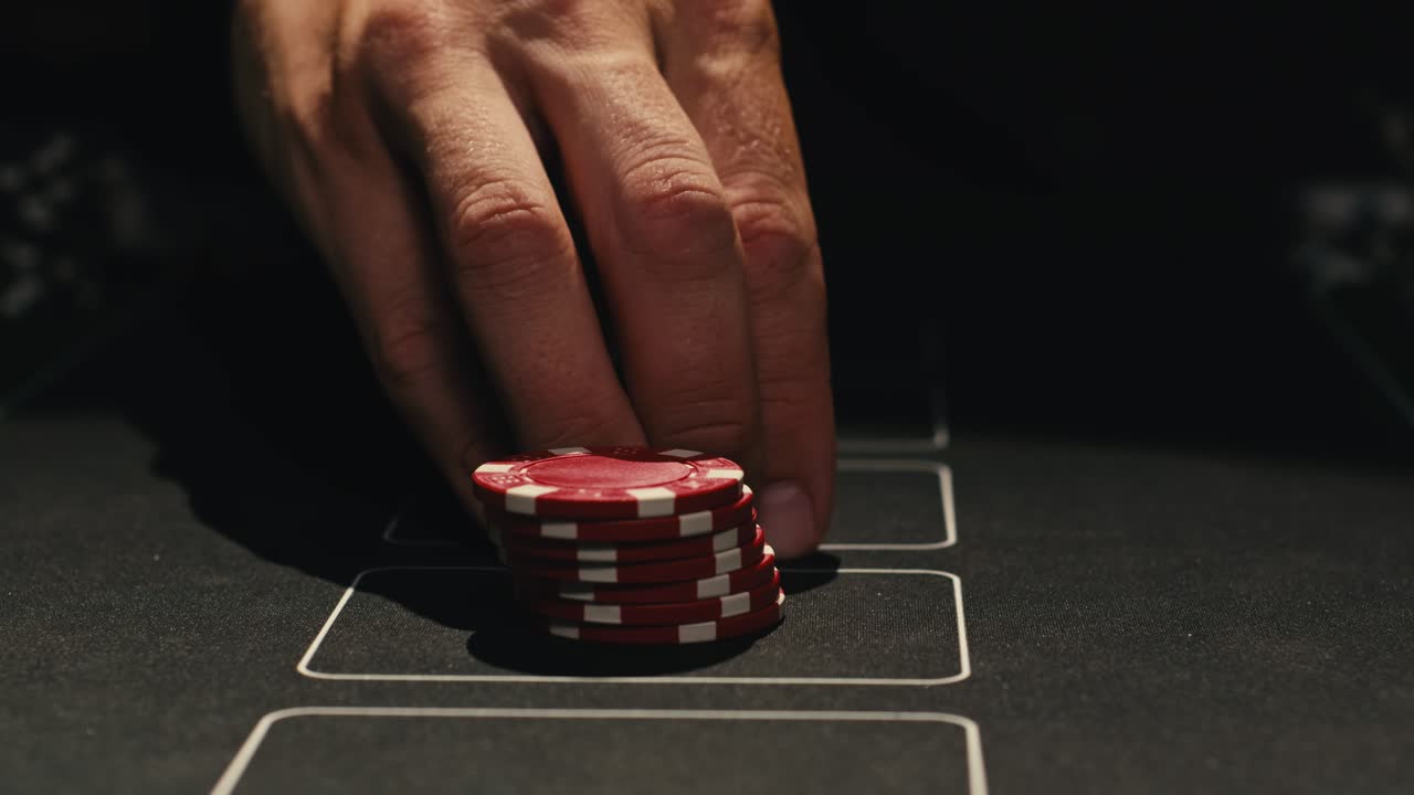 Hands managing poker chips on green table, reflecting intense poker gameplay with the element of chance and skill