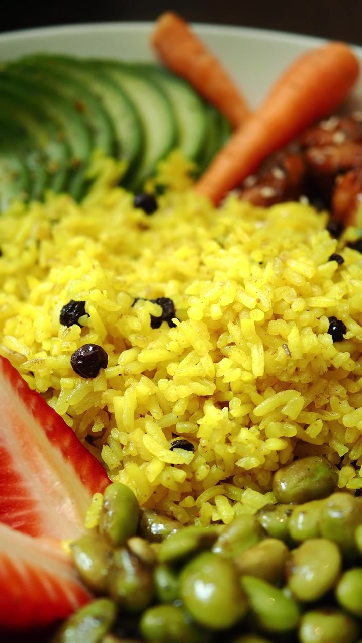 Primo piano di una Buddha Bowl vibrante e salutare con riso giallo e verdure fresche