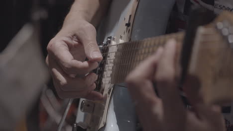 close-up man playing electric guitar