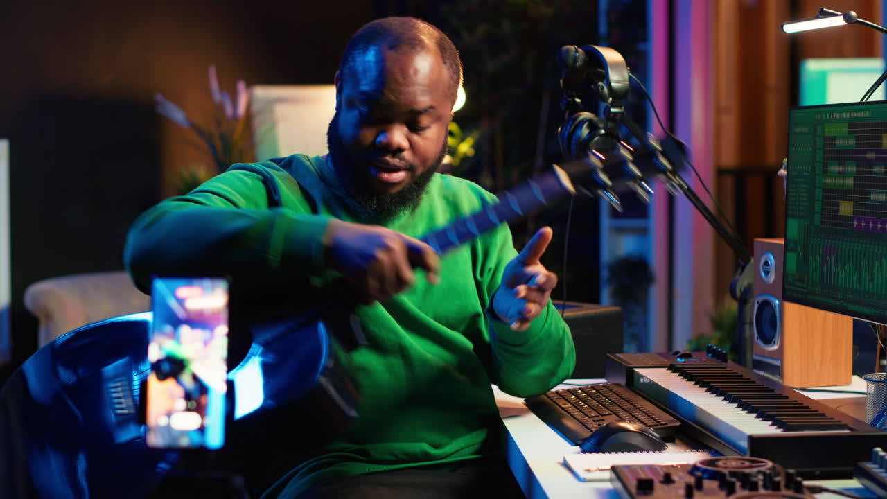 instructor de guitarra que ofrece clases de guitarra en línea usando un teléfono móvil