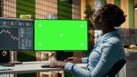 day trader in brokerage office analyzes stock market charts on green screen pc