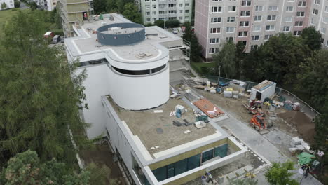 Toma-Aérea-De-Un-Sitio-De-Construcción-Con-Trabajadores-Comerciales,-Desarrollo-Arquitectónico-Industrial-Urbano