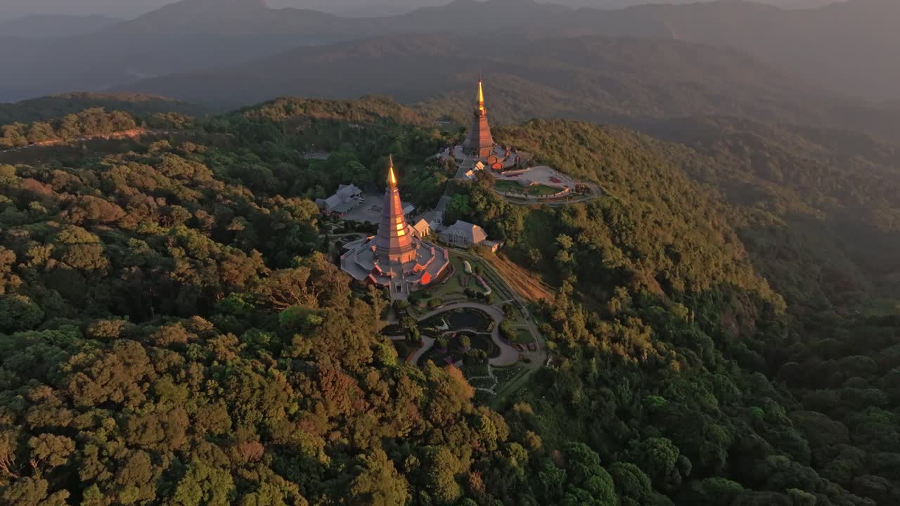 Volando su stupa illuminati dal tramonto su un crinale montuoso boscoso, Thailandia