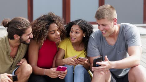 smiling young friends using smartphones