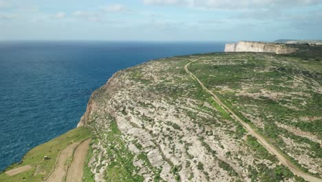 AERIAL:-Rocky-Hills-near-Ta-Cenc-Cliffs-and-Blue-Mediterranean-Sea