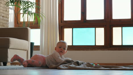 baby girl lying on the floor and playing