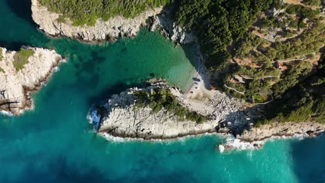 a rocky coastline and clear blue water surrounded by lush greenery and cliffs, aerial view