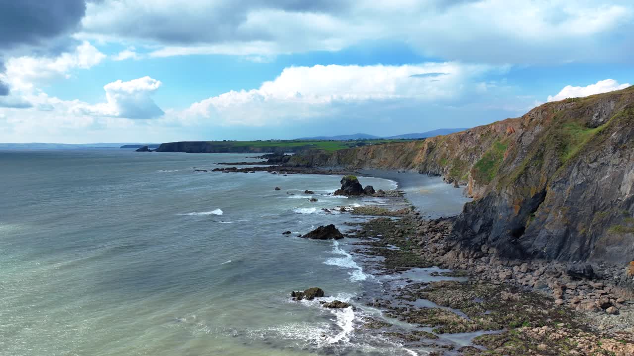 irlanda drones épicos volando a lo largo de la costa escarpada nubes dramáticas y sombras costa de waterford irlanda en verano