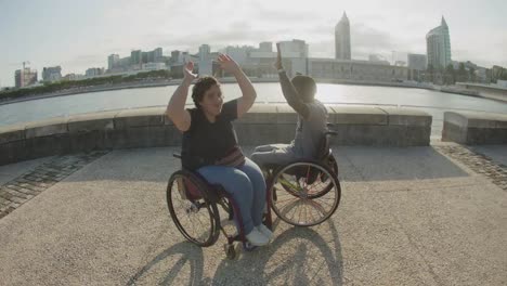 happy couple using wheelchairs dancing waving hands