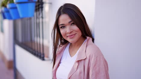 mujer con chaqueta rosa, sonriendo al aire libre