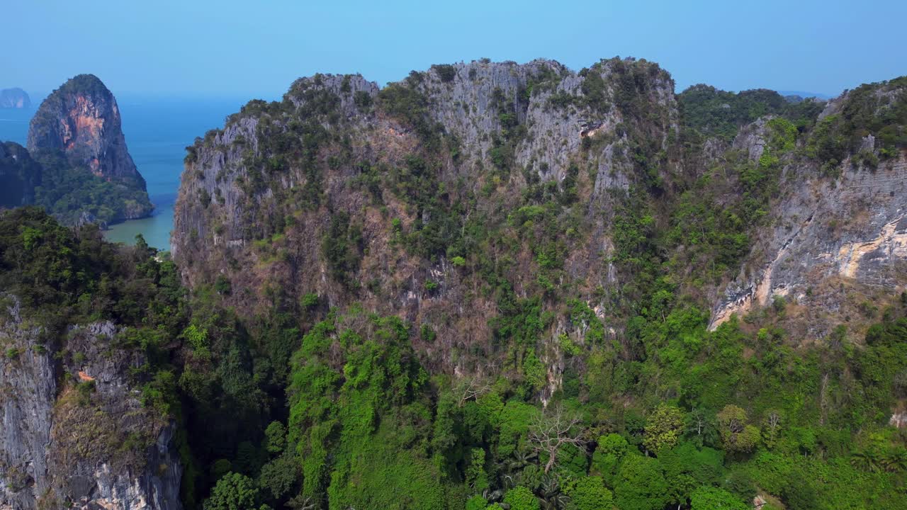 dense tropical rainforest covering steep limestone mountains in Thailand. Best aerial view flight overflight flyover drone