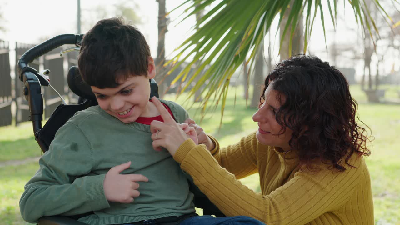 A child in a wheelchair interacts with a woman