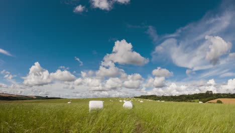 movement of clouds and wind in the field with haylage roll silage, time lapse clip