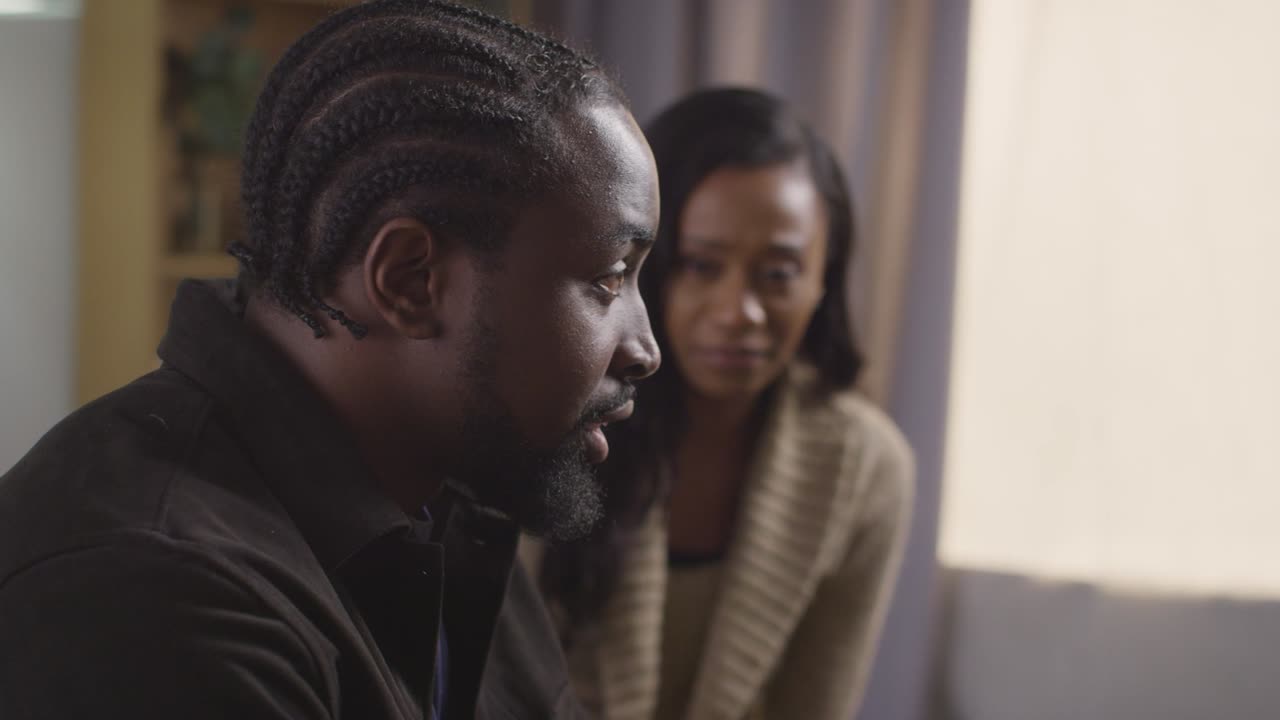 Couple At Home Sitting On Sofa In Lounge Having Break Up Argument 5