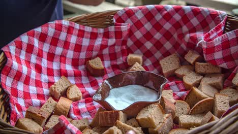 Hand-dipping-slice-of-bread-into-a-white-sauce