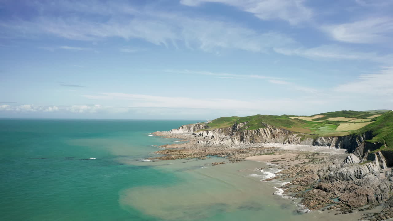 고요하고 화창한 날에 바위가 많은 해안선의 공중 비행