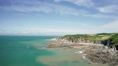 aerial flyover of a rocky coastline on a calm sunny day