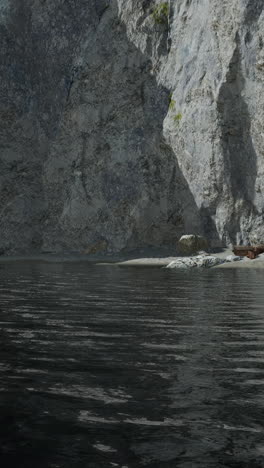 a serene view of a still lake, a rocky cliff and a sandy beach