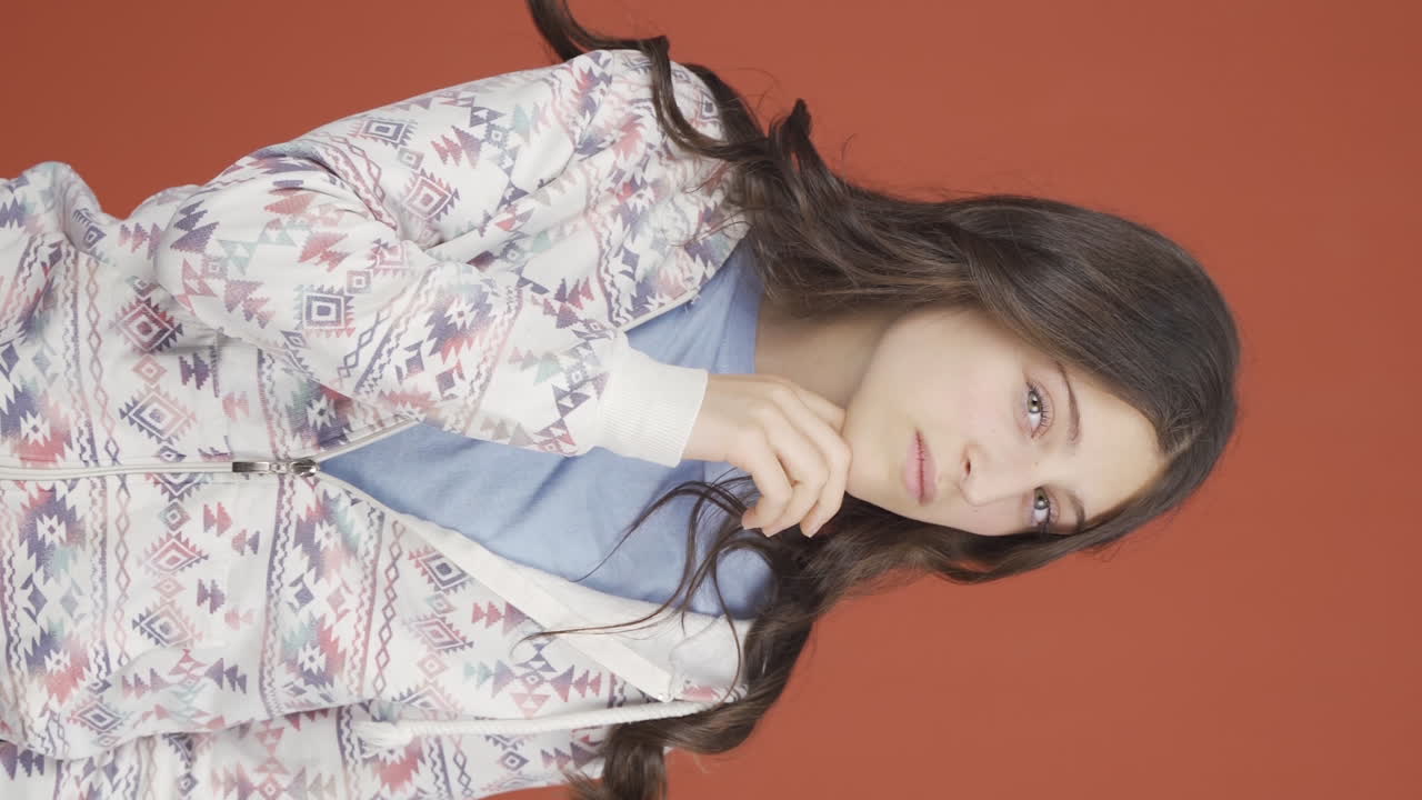 video vertical de una mujer joven mirando a la cámara con una expresión curiosa.