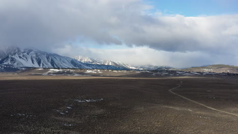 Fly-over-Owen's-valley-natural-landscape-in-California-with-the-Eastern-side-of-the-Sierra-Nevada-mountain-chain-covered-with-snow-on-the-background