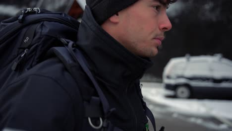 man in a black jacket and a cap walking in the streets of hallstatt in austria in winter, december